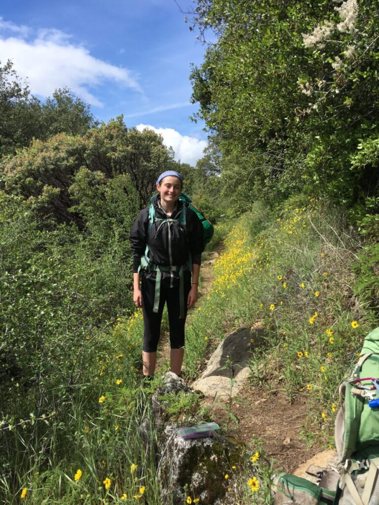 Abbie backpacking in flowers