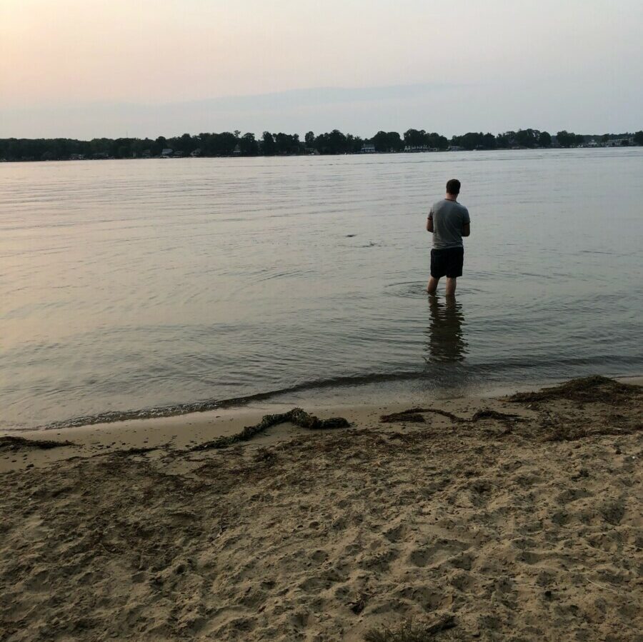 Jacob fishing in the ocean at sunset