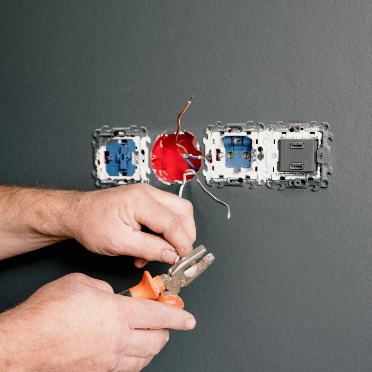 hand cutting wires in outlet